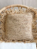 bohemian natural handwoven straw fringe pillow on wicker chair