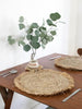 table for two in earth inspired bohemian dining room with raffia fringe placemats with a vase of eucalyptus 