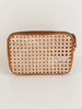 product photo of detail on bohemian rattan and brown leather market fanny pack on white surface