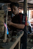 artisan welding rattan to make handmade mirror
