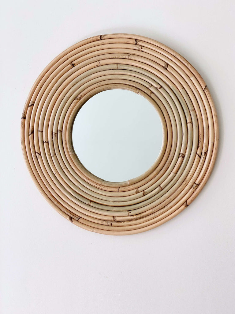 handmade rattan ring mirror on white wall 