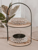 set of eight handmade rattan shell coasters displayed on two tier coaster holder on bohemian dining table