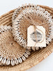 wicker basket bundle of four bohemian handwoven rattan shell coasters on white table