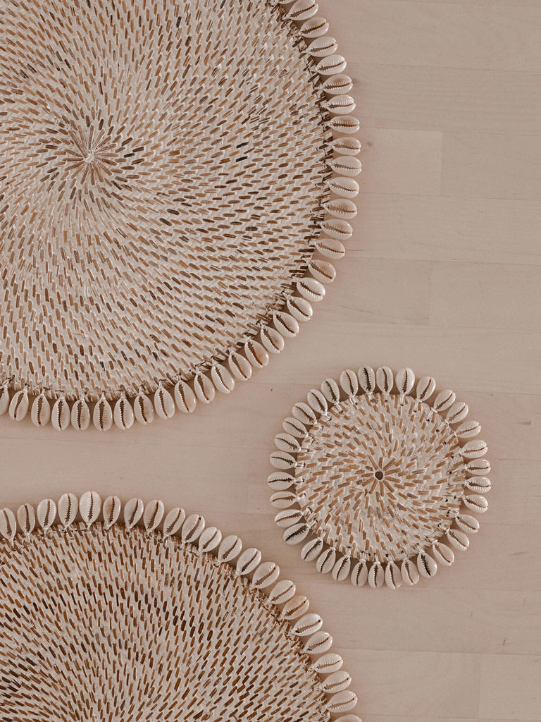 closeup of aesthetic boho tablescape decorated with rattan shell placemats and coaster
