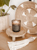 cute wooden riser with lit candle surrounded by small monstera plant and other bohemian accent decor