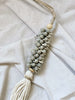 closeup of detail on handmade gray shell cluster cotton tassel on top of white canvas