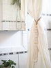 shell disc stack tassel used as shower curtain tie-back in modern bohemian bathroom