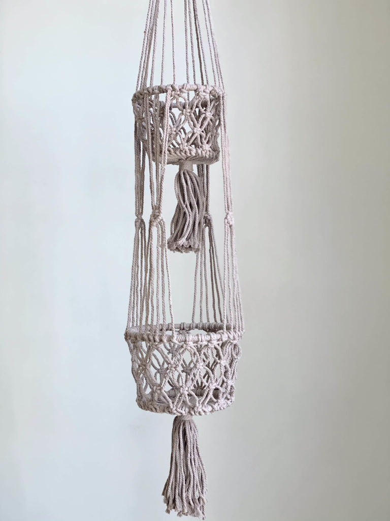 product photo macrame plant hanger holds two plants in a taupe color