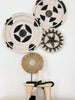 trio of black and white wall baskets on top of wooden stool with black wooden bead shell tassel and timor statue
