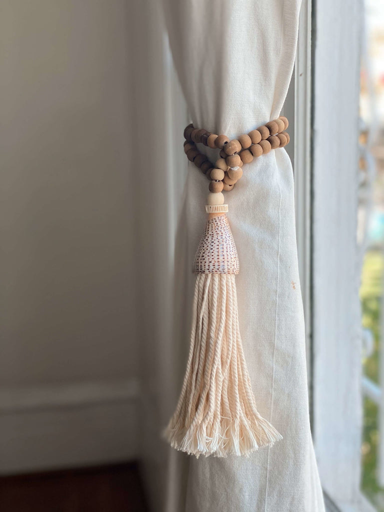 handcarved boho brown beads and conus shell tassel as curtain tie on white linen curtains
