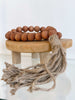 bohemian handcarved brown wooden bead jute tassel on small wooden stool