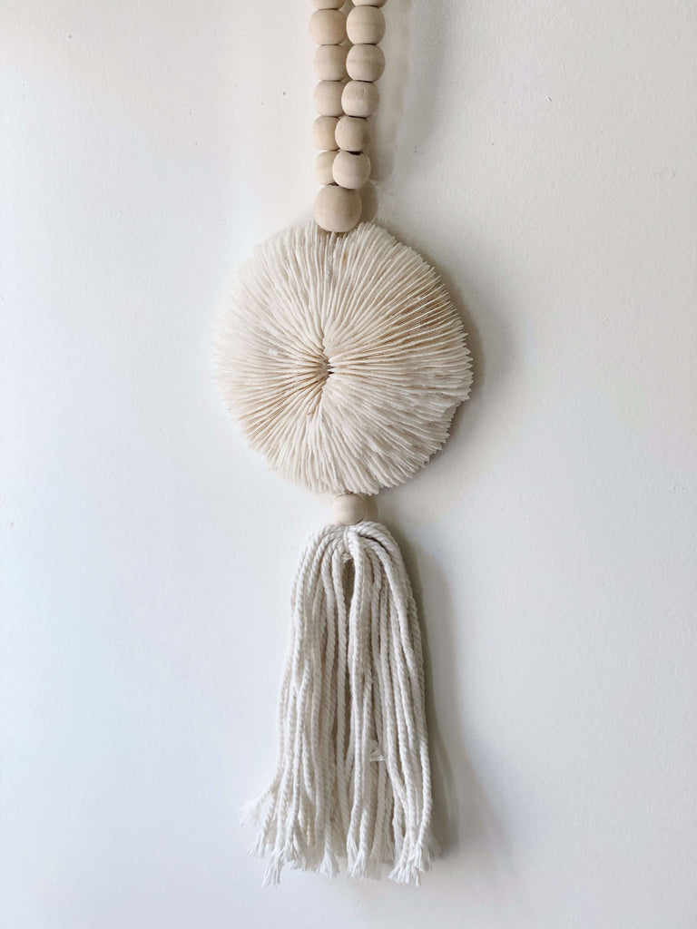 product photo of detailed unique natural wooden bead round shell tassel detail hanging on white wall
