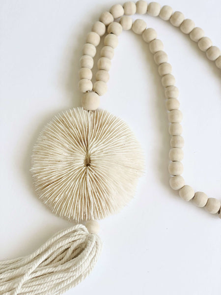 product photo of detailed unique bohemian wooden bead round mushroom coral shell tassel detail on white background