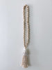 product photo of handcarved natural boho wooden bead conus shell tassel hanging on white wall