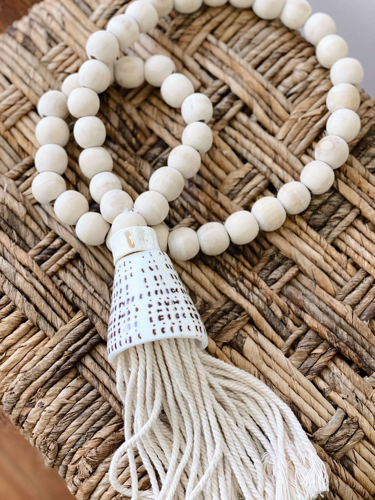 product photo of handcarved boho natural wooden bead conus shell tassel on banana leaf placemat
