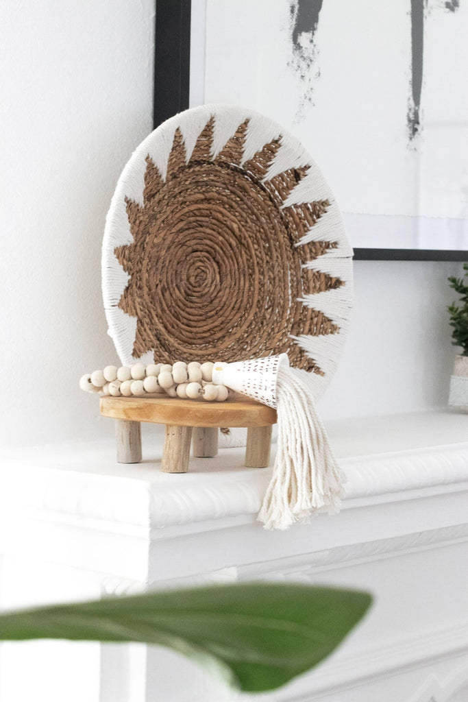 natural wooden bead shell tassel on wooden stool next to handwoven boho wall basket on mantel in modern boho room