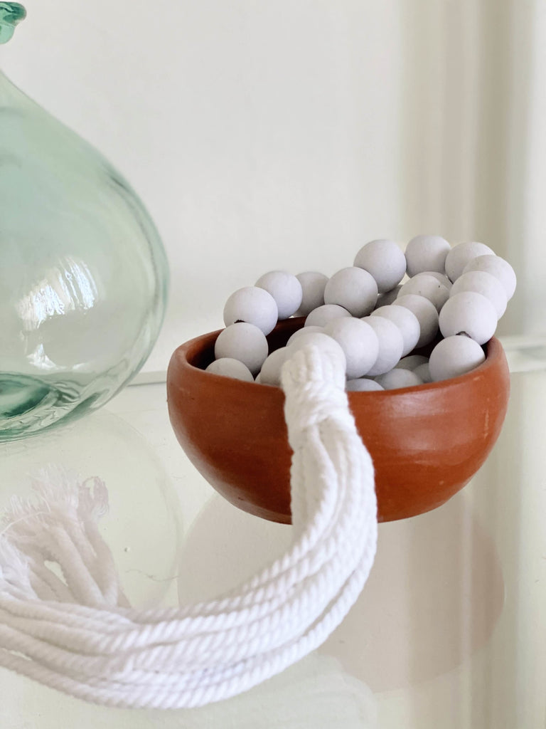 boho white handmade farmhouse bead tassel styled in ceramic bowl on glass top table