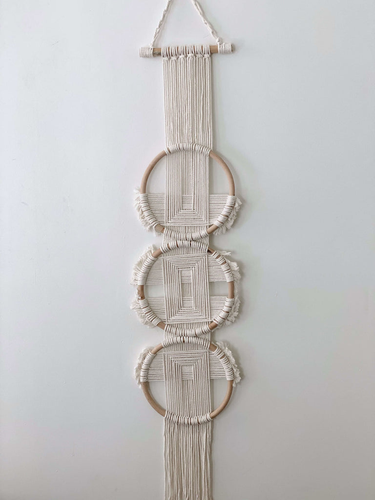 closeup of small bohemian rattan ring trio woven wall hanging tapestry on white wall